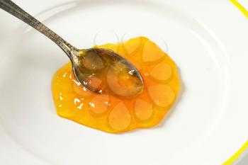 Spoon of apricot jam on plate