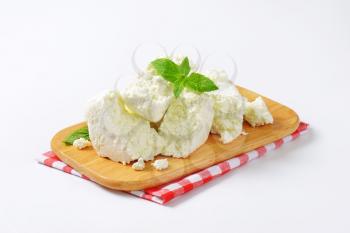 Crumbly white cheese on cutting board
