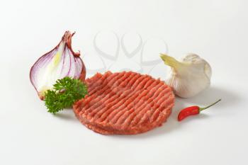 raw hamburger patty, onion and garlic