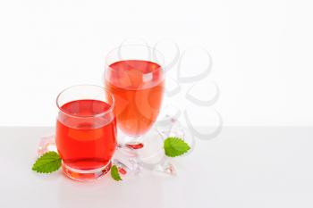 Two glasses of red fruit flavored drinks