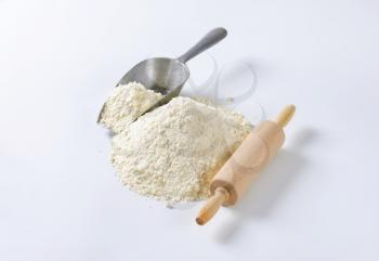 Pile of finely ground flour, wood rolling pin and metal scoop