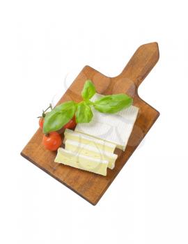 Sliced soft cow's milk cheese on cutting board