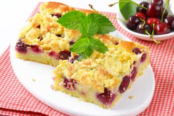 Sour cherry crumb bars on white wooden serving board