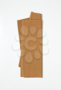 Folded brown woven cotton place mat