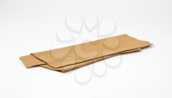 Folded brown woven cotton place mat
