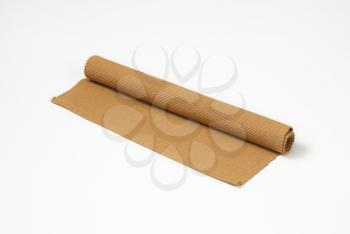 Rolled brown woven cotton place mat