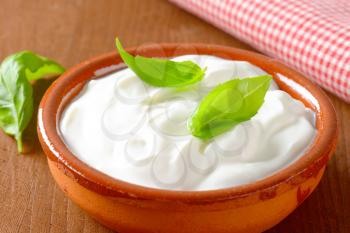 white yogurt or sour cream in a ceramic bowl