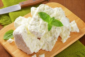 Crumbly white cheese on cutting board
