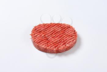 raw hamburger patty on white background