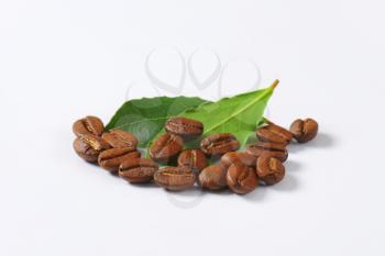 Handful of roasted coffee beans on white background
