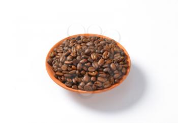 Medium roasted coffee beans in terracotta bowl