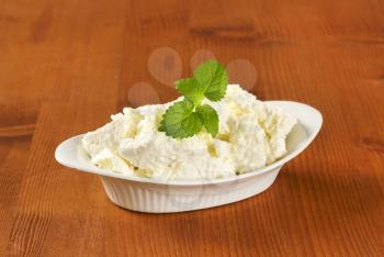 pieces of fresh curd cheese in white bowl