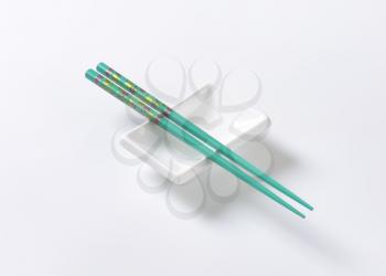A pair of blue chopsticks on empty soy sauce dish