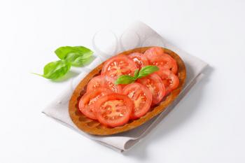sliced tomato in wooden bowl