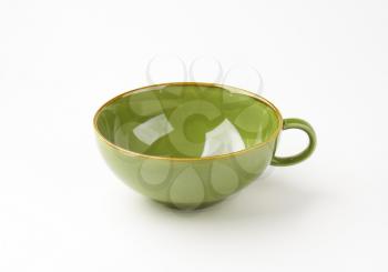 empty green soup bowl with one handle on white background