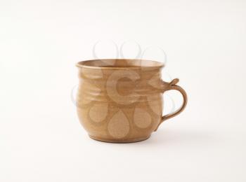 handcrafted brown ceramic coffee cup on white background