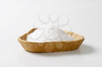 Coarse grained salt in triangle wooden bowl