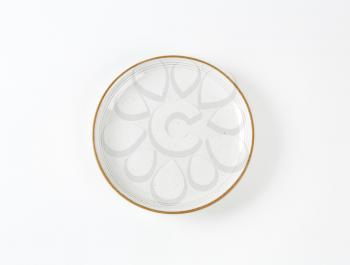 Glazed ceramic soup plate with brown trim
