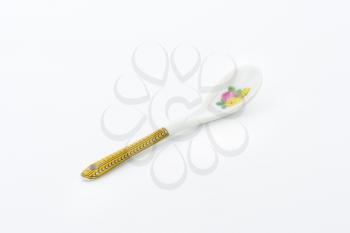 White spoon with floral and ornate print