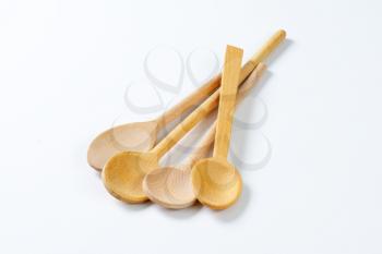 four wooden spoons on white background