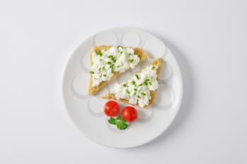 bread with cottage cheese and chives on white plate