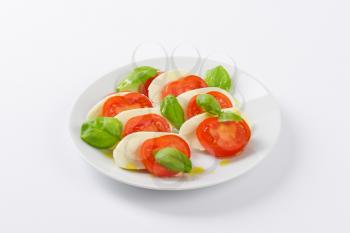 plate of fresh caprese salad on white background