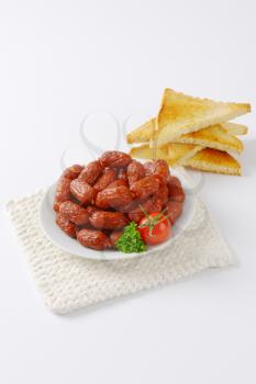plate of mini cabanossi sausages with toasted white bread