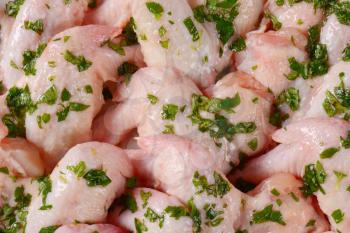 detail of raw chicken wings with chopped parsley