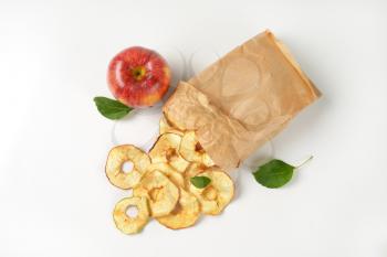 fresh red apple and dried apple rings coming out of paper bag