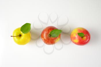three ripe apples in a row on white background