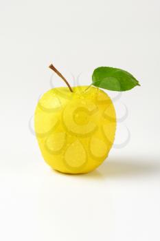 washed yellow apple on white background