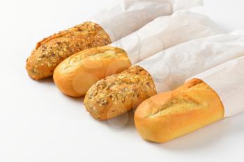 white and whole grain baguettes in paper bags