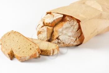 freshly baked loaf of bread in paper bag