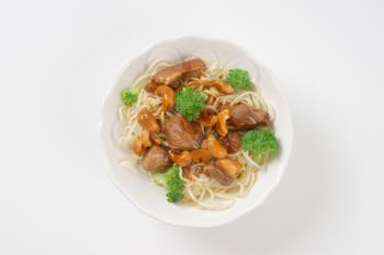 Stir-fried beef with cashews and broccoli served with noodles