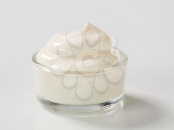Swirl of smooth white cream in a small glass bowl