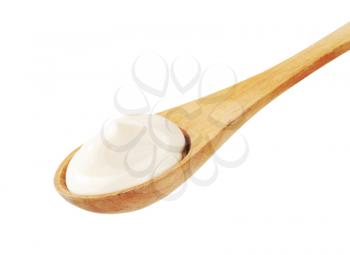 Fresh white cream on a  small deep wooden spoon