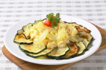 Roasted zucchini slices with potato and egg scramble