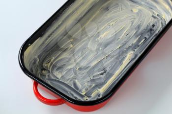 red baking pan greased with butter