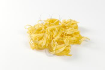 Dried ribbons of pasta coiled into nests