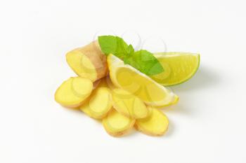 sliced ginger with lemon and lime on white background