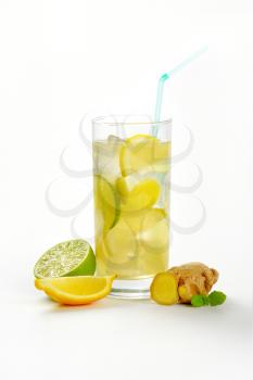 glass of homemade ginger ale with lemon, lime and ice
