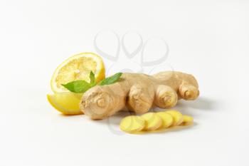 sliced ginger with lemon on off-white background with shadows