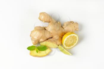 fresh ginger root with lemon and lime on white background