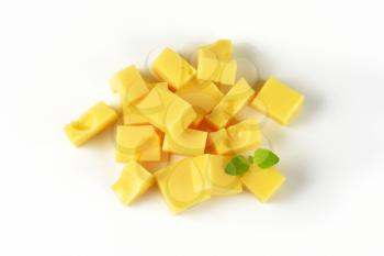 handful of diced emmental cheese on white background