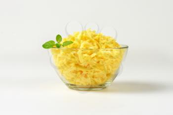 bowl of grated cheese on white background