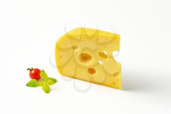 wedge of medium-hard Swiss cheese on white background