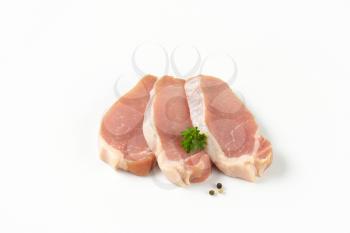 raw boneless pork loin chops on white background