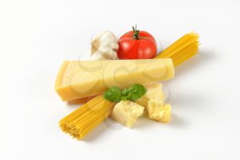 parmesan cheese, vegetables and bundle of raw spaghetti