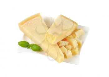 wedges and pieces of parmesan cheese on white plate