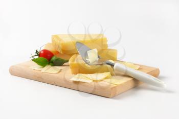 parmesan and cheese slicer on wooden cutting board